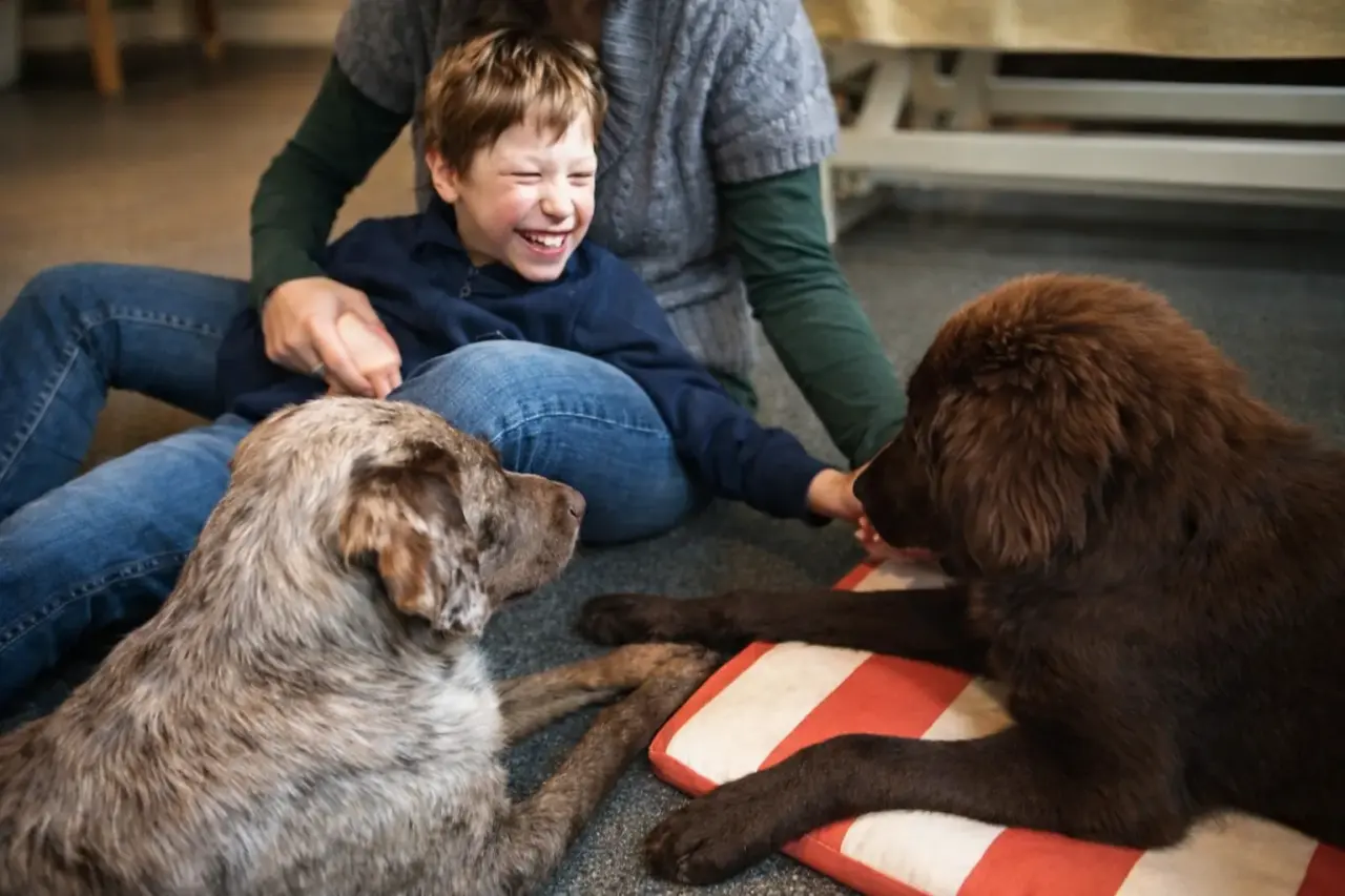 Kind lacht bei der Hundetherapie